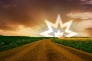 A voided mullet of 8 points with a crown in the centre rising over a dirt road surrounded by green fields.